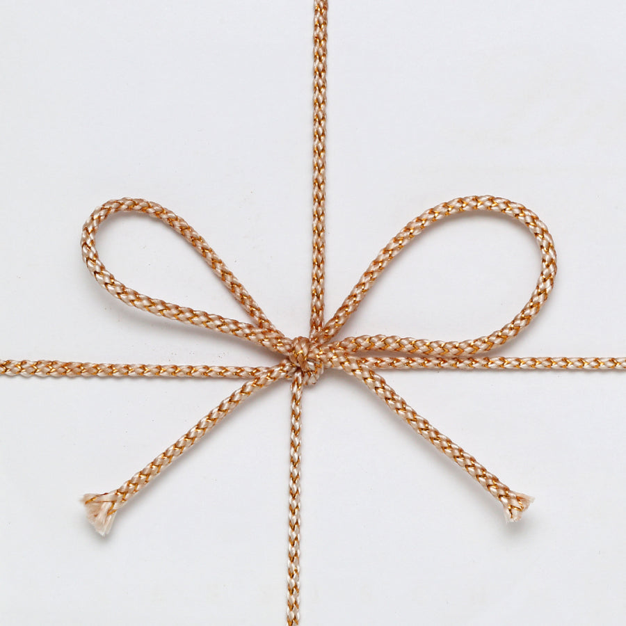 A gold ribbon tied over a white surface